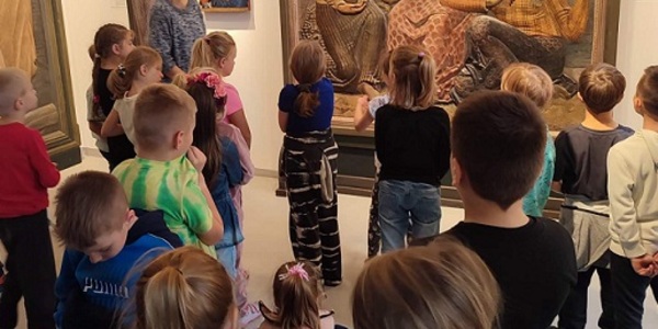 Uczniowie stoją w galerii przed obrazami