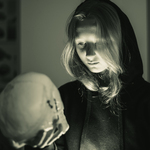 Czarno-białe zdjęcie dziewczyny z czaszką w ręku.