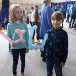 chłopiec i dizewczynka trzymaja w rękach zwierzątka zrobione z balonów.