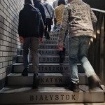 Uczniowie wchozący po schodach, na których są napisy miejsc.