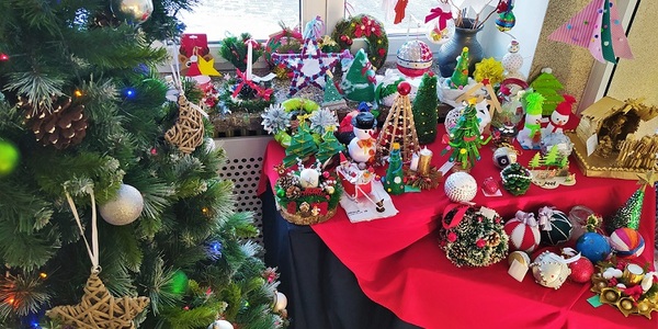 Stół z ozdobami świątecznymi oraz choinka.