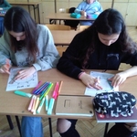 Dwie uczennice wykonują kartę pracy siedząc w ławce.