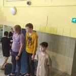 Troje uczniów stoi na podium.