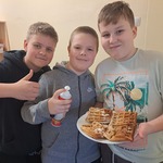 Trzech uczniów trzyma gofry.
