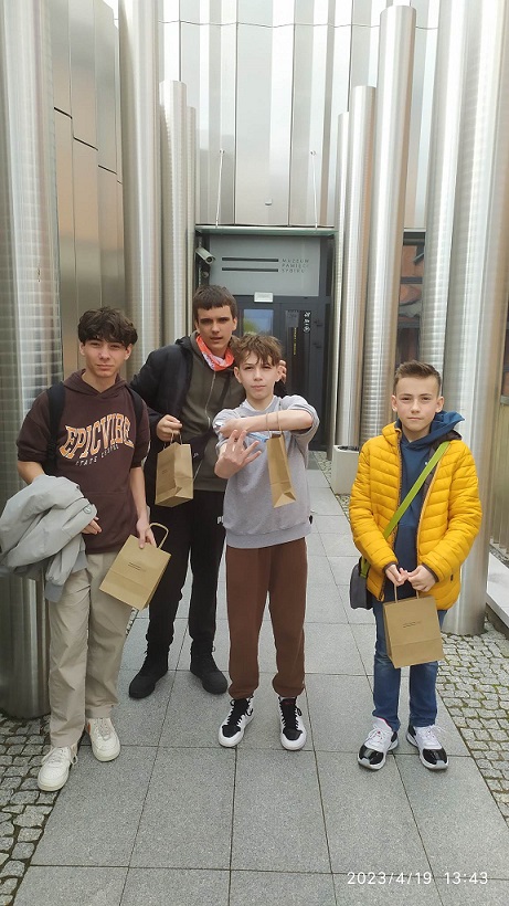 4 chłopców stoi na tle wejścia do muzeum..jpg