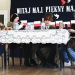 Czterech uczniów przebranych w stroje szlacheckie siedzi przy stole.