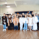 Duża grupa uczniów wraz z dwiema nauczycielkami stoi przed publicznością.