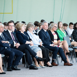 Zgromadzeni goście - osoby dorosłe elegancko ubrane-siedzą na krzesłach
