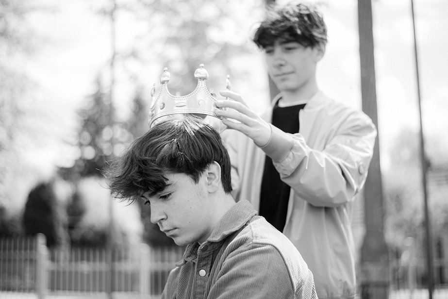Chłopak wkłada koronę koledze.