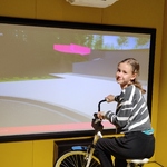 Dziewczynka jedzie na symulatorze roweru..jpg