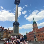 Uczniowie stoją w centrum Warszawy.