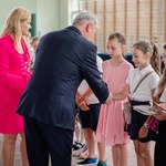 Pan dyrektor wraz z nauczycielką wręcza książki i podziękowania młodszym uczniom.