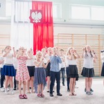 Uczniowie ubrani na galowo występują na uroczystości.