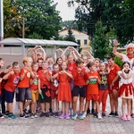 Grupa uczniów ubrana na czerwono wraz z nauczycielką robią z dłoni serduszka.