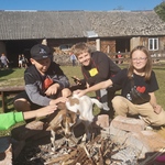 Dzieci głaszczą kozę przy ognisku..jpg