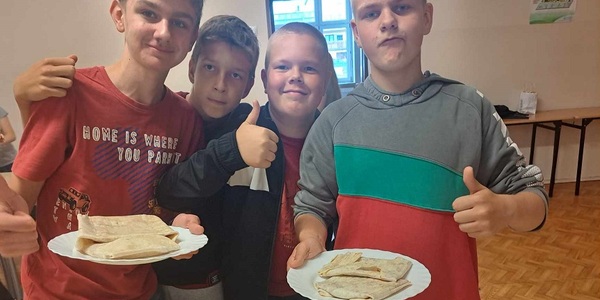 Czterech chłopaków trzyma talerze z naleśnikami.jpg