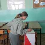 Dziewczyna wrzuca kartę do głosowania do urny