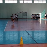 Uczniowie wykonują ćwiczenia na hali sportowej.