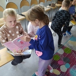 Dziewczynki pokazują sobie książki w bibliotece..jpg