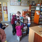 Uczniowie szukają książek na półce w bibliotece..jpg