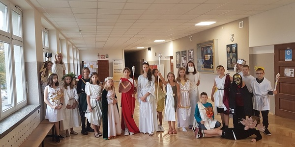 Grupa uczniów przebrana za greckich bogów stoi na korytarzu szkolnym..jpg
