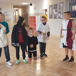 Grupa chłopców przebrana za greckich bogów stoi na korytarzu..jpg