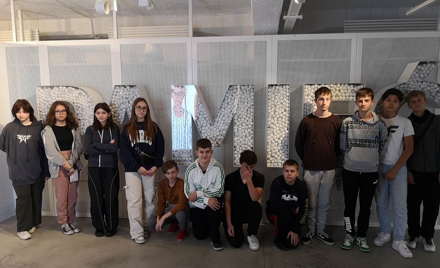 Grupa uczniów stoi przy napisie wykonanym z białych piłeczek..jpg