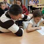 Rodzice  pomagają dzieciom pisać dyktando w klasie.1.jpg