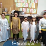 Uczniowie stoją pod tablicą.
