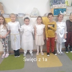 Uczniowie przebrani za świętych pozują do zdjęcia.