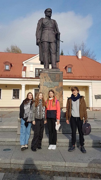 Grupa uczniów stoi przy pominku Józefa Piłsudskiego..jpg