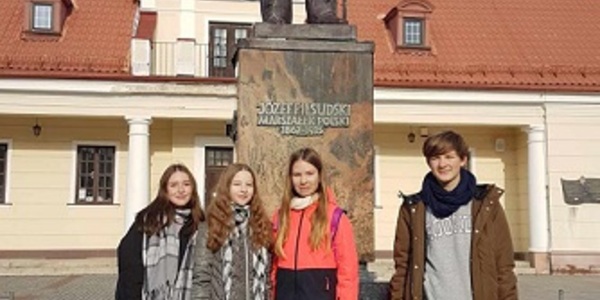 Grupa uczniów stoi przy pominku Józefa Piłsudskiego..jpg
