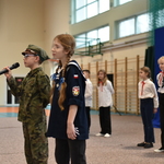 Dwoje uczniów ubancyh w mundury harcerskie występuje przed publucznością.
