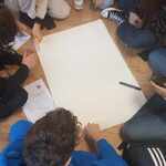 Grupa uczniów zastanawia się nad białym arkuszem papieru..jpg