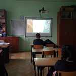 Uczniowie w klasie oglądaja film na ekranie na ścianie..jpg