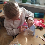 Uczennica wykonuje lampion przy użyciu kleju.
