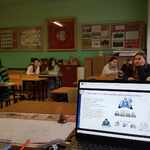Uczniowie siedzą w klasie_ na pierwszym miesjcu widać ekran laptopa..jpg