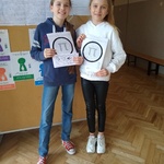 Dwie dziewczynki trzymają w rękach kartki z liczbą pi..jpg