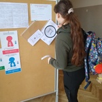 Dziewczyna wyjmuje kartkę z koszulki foliowej na tablicy..jpg