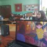Widok monitoru laptopa oraz uczniów sidzących w klasie..jpg