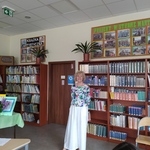 Kobieta w kolorowej bluzce na tle regałów z książkami..jpg