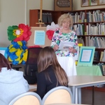 Poetka czyta swoje wiersze z książki w bibliotece szkolnej..jpg