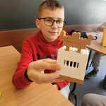 Chłopak trzyma w ręku budowlę z klocków lego..jpg