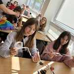 Uczennice pokazuja wykonane wstęgi z papieru.jpg
