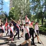 Grupa uczniów ubranych w stroje galowe idzie z pocztami sztandarowymi..jpg