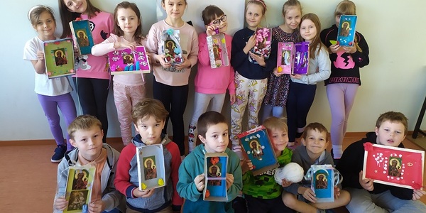 Grupa dzieci pozuje do zdjęcia trzymając w rękach pudełka z obrazkami Maryi..jpg