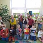 Dzieci stoją w bibliotece i trzymają w rękach pudełka z obrazkami Maryi.jpg