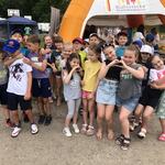 Grupa dzieci razem z nauczycielką pozują do zdjecia przy nadmuchanej bramie.jpg