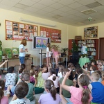Dwie dziewczynki stoją przy tablicy_ obok stoi pisarka_ która razem z reszta uczniów patrzy w kierunku dziewczynek..jpg