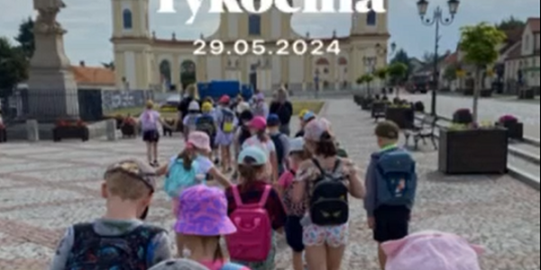 Grupa dzieci idąca za ręce przez duży plac..PNG